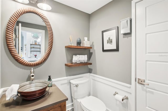 7540 Sunshine Skyway Ln S Unit 217, Saint Petersburg, FL 33711 - bathroom with vanity, toilet, and a wainscoted wall