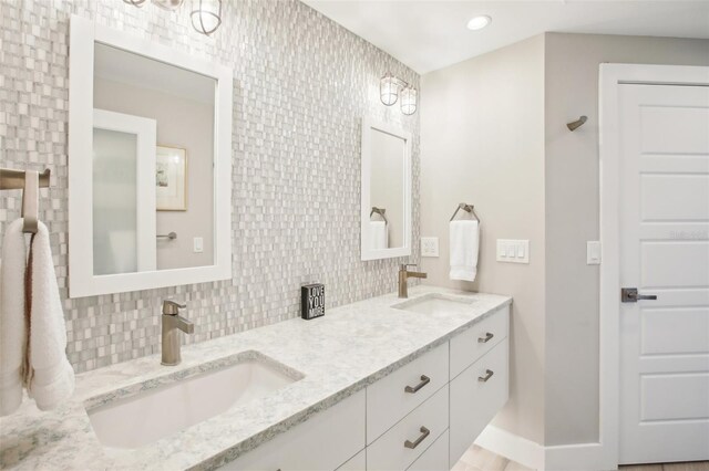 7540 Sunshine Skyway Ln S Unit 217, Saint Petersburg, FL 33711 - full bathroom featuring double vanity, a sink, baseboards, and tasteful backsplash