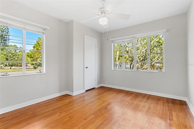 empty room featuring a ceiling fan, light wood-style flooring, and baseboards