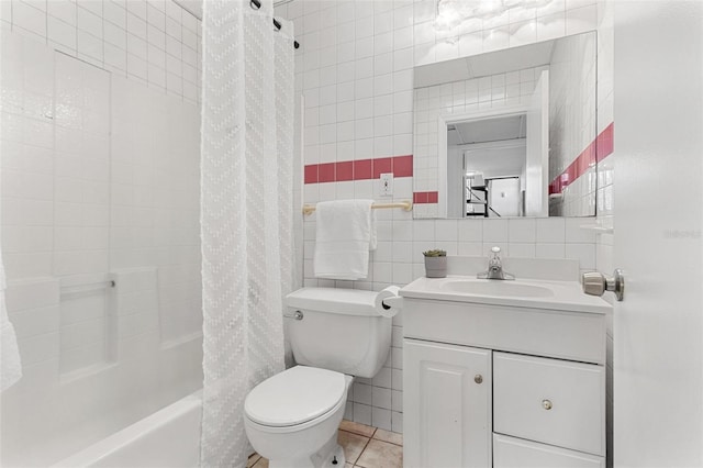 full bath with tile walls, vanity, shower / bath combo with shower curtain, tile patterned floors, and toilet