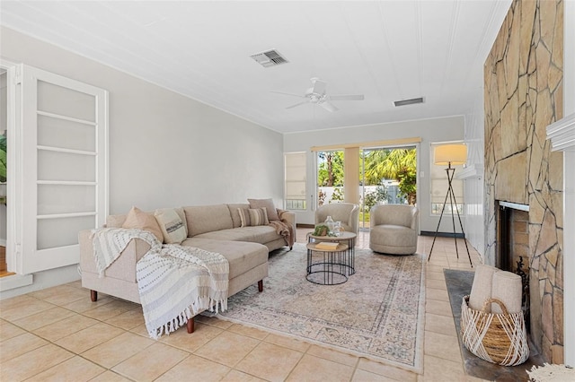 tiled living room with a fireplace, visible vents, and a ceiling fan