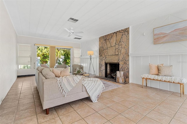 tiled living room with visible vents, a ceiling fan, and a fireplace