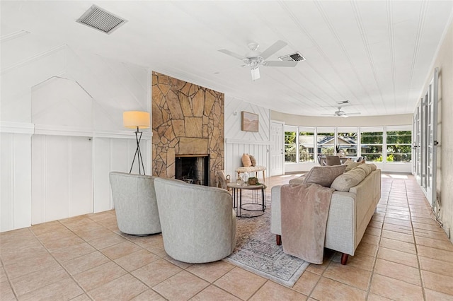 living area with a ceiling fan, visible vents, and a fireplace