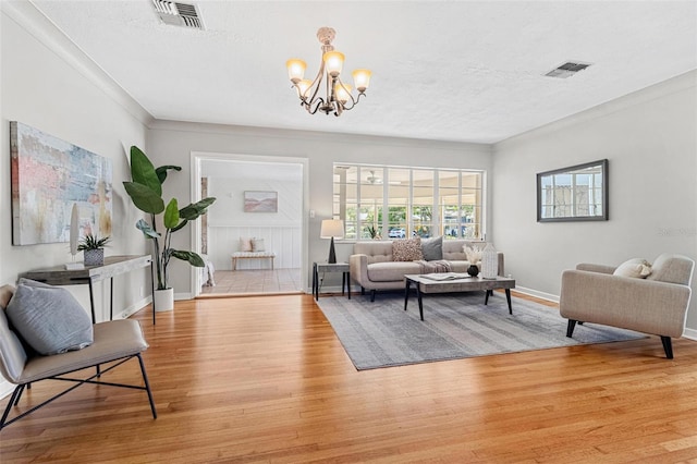 living area with a chandelier, visible vents, light wood-type flooring, and baseboards