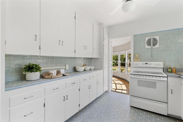 kitchen with white cabinets, decorative backsplash, and white electric range oven