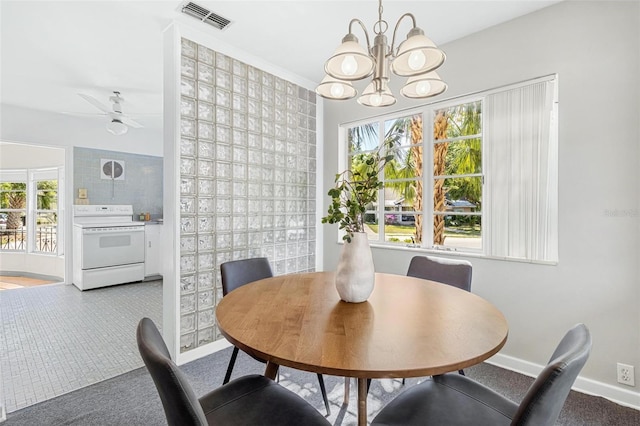 carpeted dining room featuring baseboards, visible vents, ceiling fan with notable chandelier, and plenty of natural light