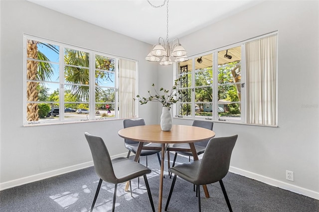 dining room with carpet, a chandelier, and baseboards