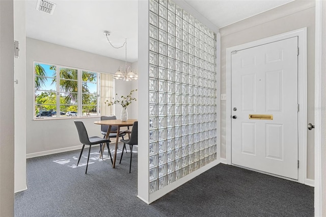 entrance foyer with dark carpet, visible vents, a chandelier, and baseboards