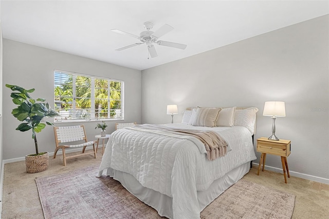 bedroom featuring a ceiling fan, light colored carpet, and baseboards