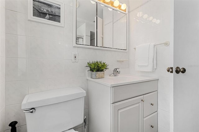 bathroom featuring tile walls, toilet, and vanity
