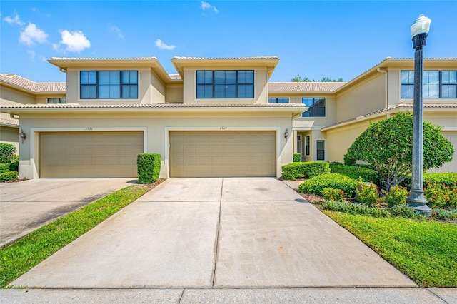 2527 Silverback Ct, Palm Harbor, FL 34684 - townhome / multi-family property featuring a tiled roof, an attached garage, concrete driveway, and stucco siding