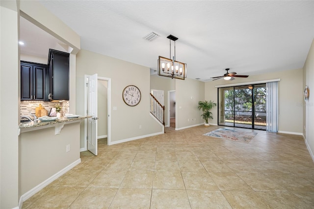 2527 Silverback Ct, Palm Harbor, FL 34684 - unfurnished living room featuring light tile patterned flooring, baseboards, visible vents, ceiling fan with notable chandelier, and stairway