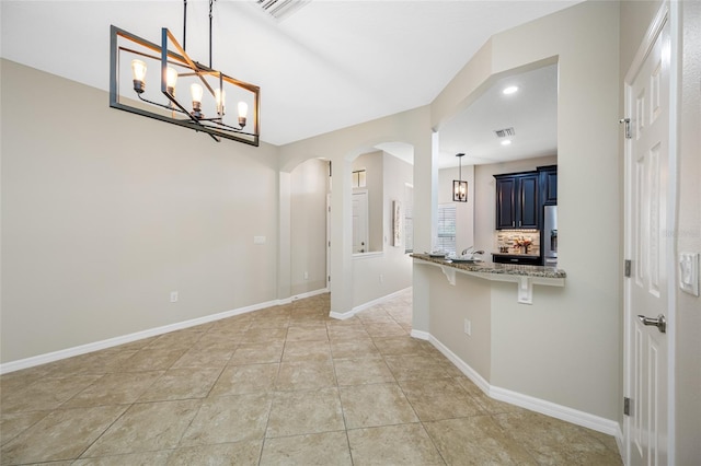 2527 Silverback Ct, Palm Harbor, FL 34684 - interior space with an inviting chandelier, a breakfast bar, visible vents, and arched walkways