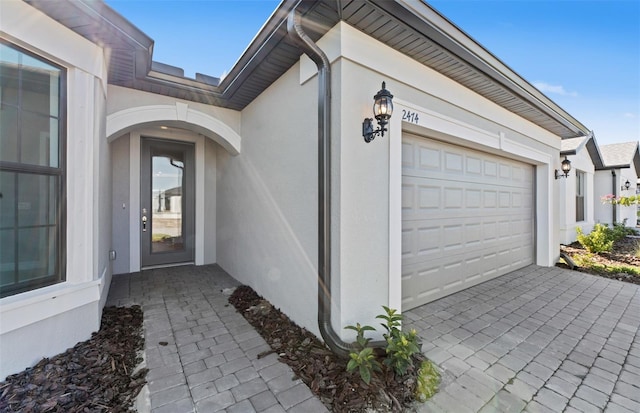 2528 Charter Oak Dr, North Port, FL 34289 - doorway to property featuring a garage, driveway, and stucco siding