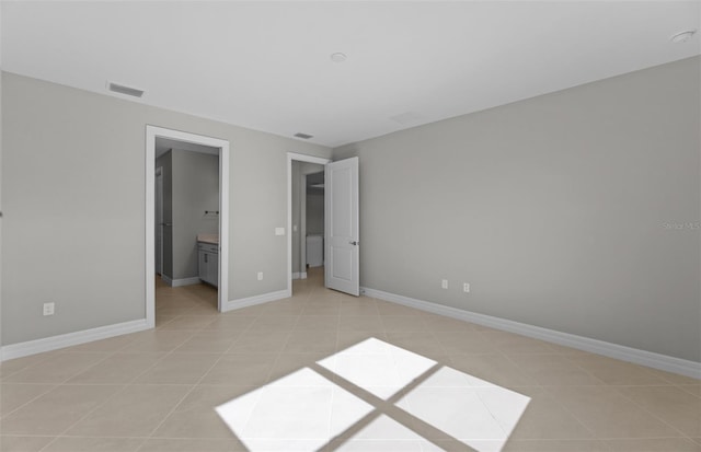 2528 Charter Oak Dr, North Port, FL 34289 - unfurnished bedroom with baseboards, ensuite bathroom, visible vents, and light tile patterned flooring