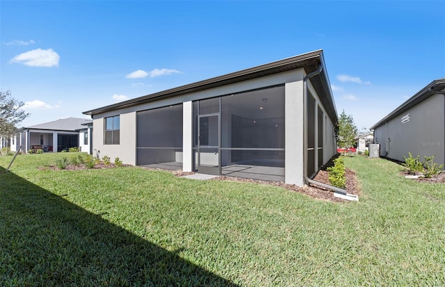 2528 Charter Oak Dr, North Port, FL 34289 - rear view of house with a lawn, a sunroom, and stucco siding