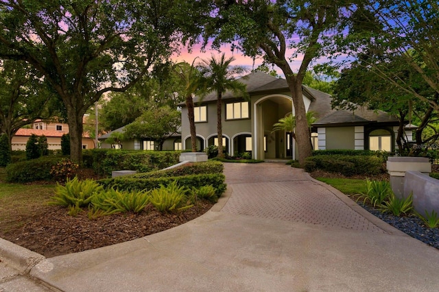 mediterranean / spanish house with decorative driveway and stucco siding