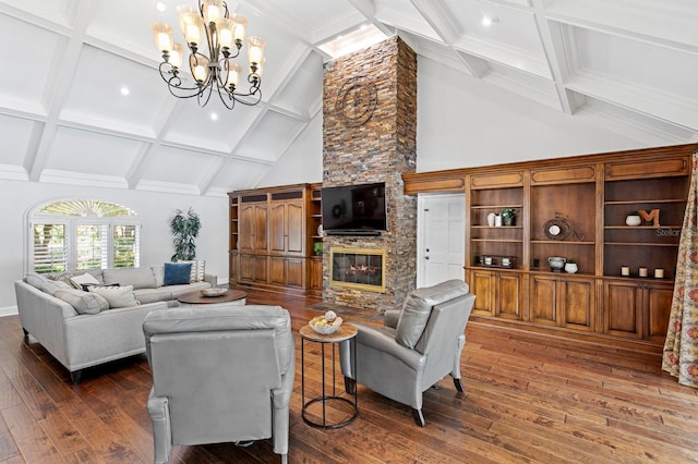 living area featuring beam ceiling, dark wood finished floors, an inviting chandelier, coffered ceiling, and a stone fireplace