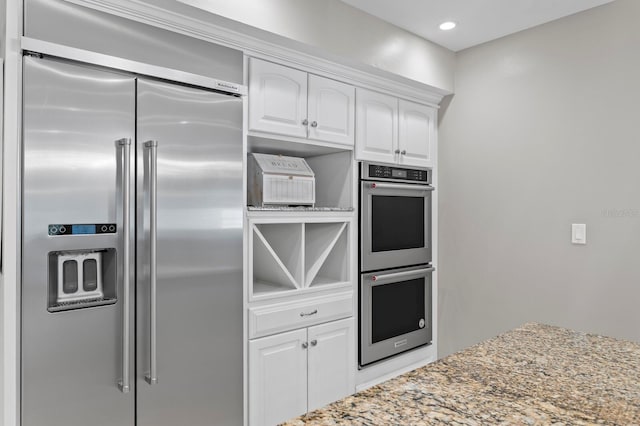 kitchen with white cabinetry, recessed lighting, light stone countertops, and appliances with stainless steel finishes