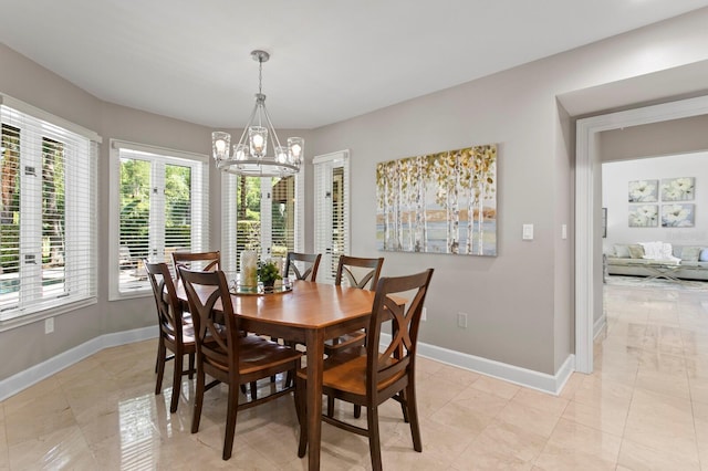 dining area with an inviting chandelier and baseboards