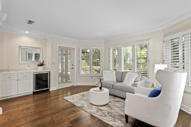 living room featuring crown molding, wet bar, and beverage cooler