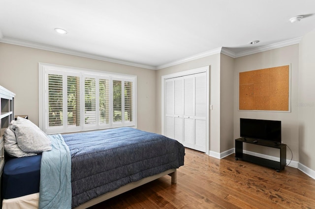 bedroom with a closet, recessed lighting, baseboards, ornamental molding, and wood finished floors