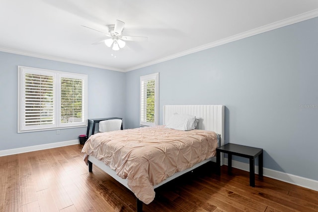 bedroom with baseboards, ceiling fan, wood-type flooring, and crown molding