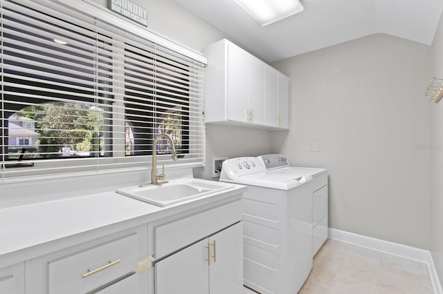 laundry area featuring light tile patterned floors, baseboards, washer and dryer, a sink, and cabinet space