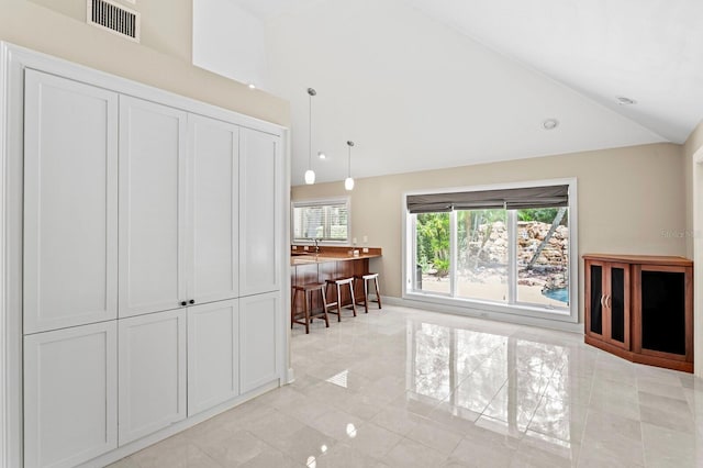 living room featuring lofted ceiling, visible vents, and light tile patterned flooring