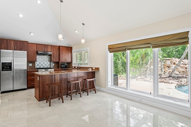kitchen featuring a peninsula, stainless steel refrigerator with ice dispenser, backsplash, under cabinet range hood, and lofted ceiling