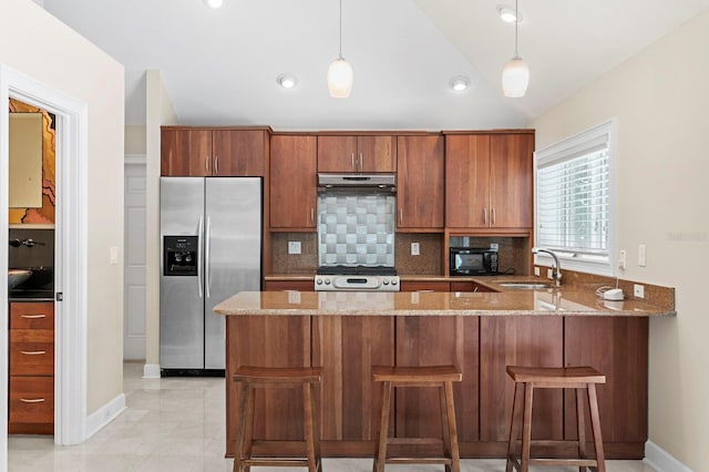 kitchen with under cabinet range hood, gas range oven, light stone counters, a sink, and stainless steel refrigerator with ice dispenser