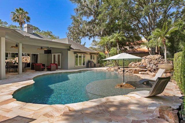 outdoor pool with an outdoor hangout area, a patio area, french doors, and ceiling fan