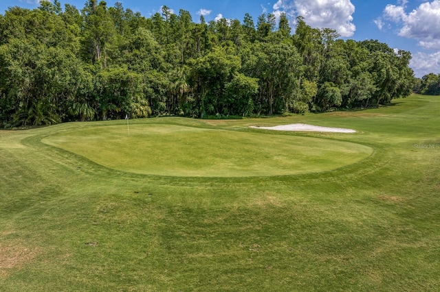 surrounding community with a yard and view of golf course