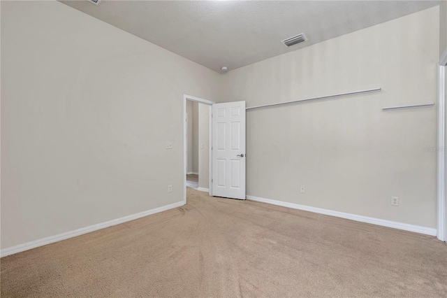 carpeted spare room with baseboards and visible vents