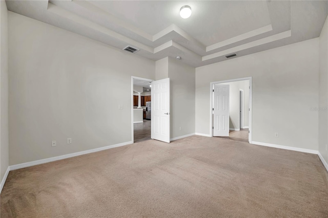 unfurnished bedroom featuring visible vents, carpet flooring, a raised ceiling, and baseboards