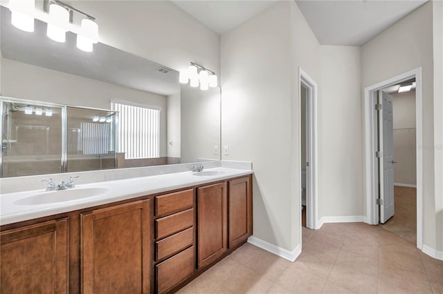 bathroom with tile patterned flooring, double vanity, baseboards, a sink, and a stall shower