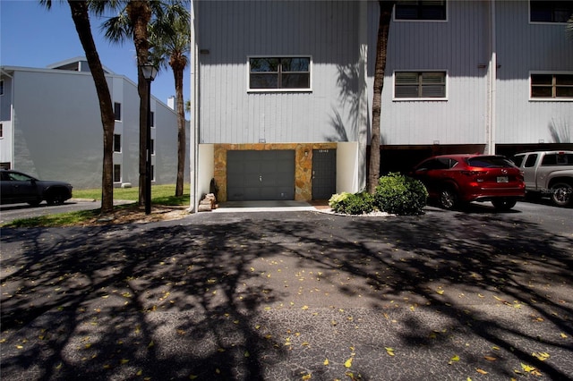 view of front facade featuring a garage and asphalt driveway