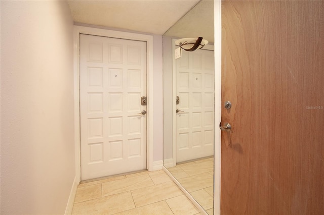 doorway to outside with baseboards and light tile patterned floors