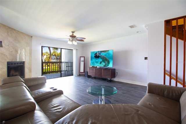 living room with wood finished floors, a ceiling fan, baseboards, a premium fireplace, and ornamental molding