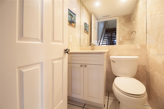 half bath featuring toilet, vanity, and tile patterned floors