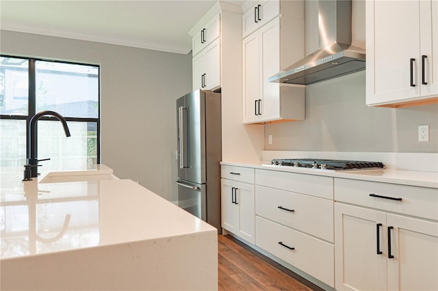 3310 W Rogers Ave, Tampa, FL 33611 - kitchen featuring wall chimney range hood, ornamental molding, high end fridge, gas cooktop, and light wood-style flooring
