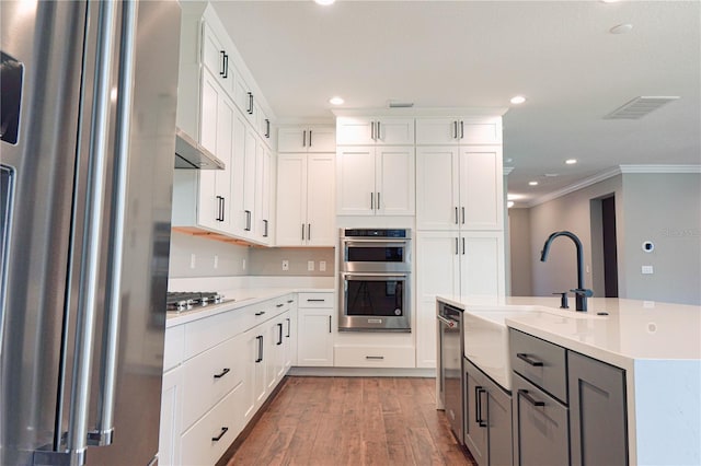3310 W Rogers Ave, Tampa, FL 33611 - kitchen featuring a sink, stainless steel appliances, crown molding, light countertops, and light wood-style floors