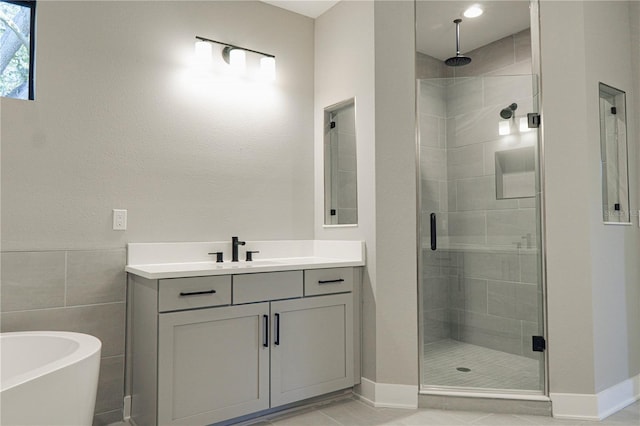 3310 W Rogers Ave, Tampa, FL 33611 - bathroom featuring a stall shower, baseboards, vanity, and a freestanding tub