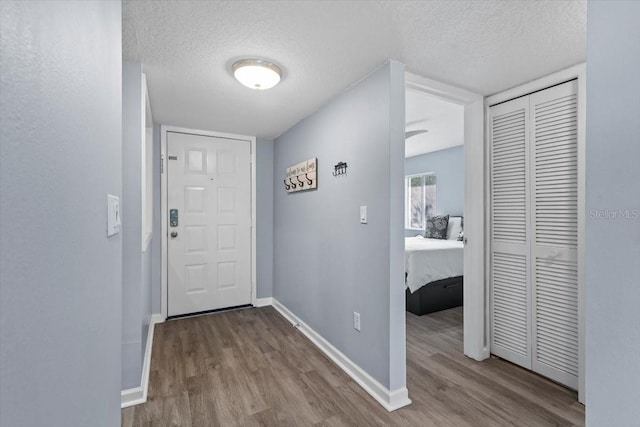 3600 Magnolia Ridge Cir Unit 1221-G, Palm Harbor, FL 34684 - doorway to outside featuring baseboards, wood finished floors, and a textured ceiling