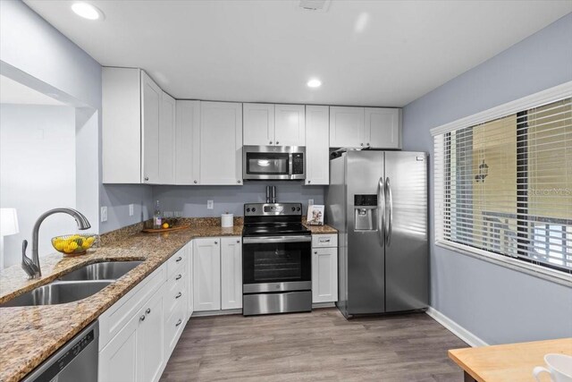 3600 Magnolia Ridge Cir Unit 1221-G, Palm Harbor, FL 34684 - kitchen with recessed lighting, light stone counters, stainless steel appliances, a sink, and white cabinetry