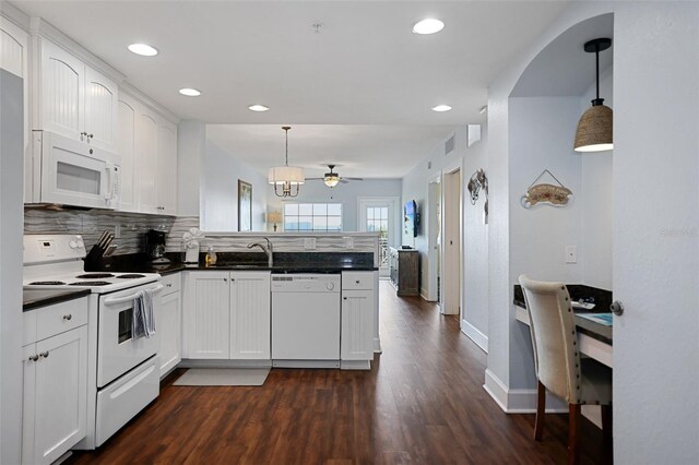 399 2nd St Unit 313, Indian Rocks Beach, FL 33785 - kitchen featuring a peninsula, white appliances, dark wood-type flooring, white cabinetry, and dark countertops
