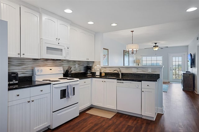 399 2nd St Unit 313, Indian Rocks Beach, FL 33785 - kitchen with a peninsula, dark wood-type flooring, a sink, and white appliances