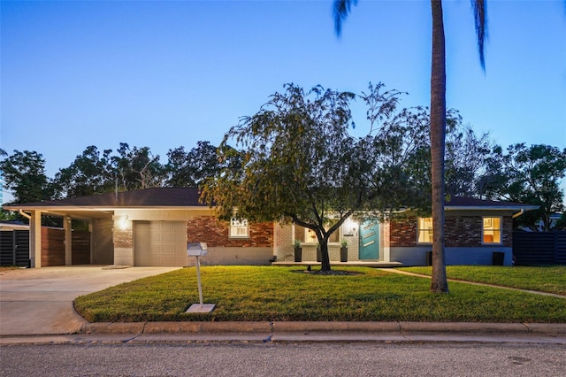 ranch-style home with concrete driveway, brick siding, a front lawn, and a garage