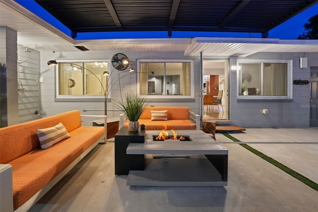 view of patio with an outdoor living space with a fire pit