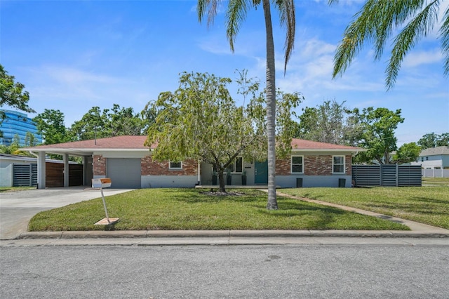 ranch-style house featuring a carport, concrete driveway, a front lawn, brick siding, and a garage